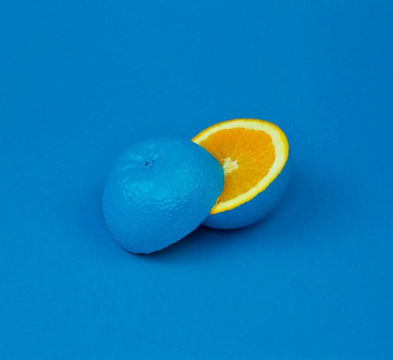 Symbolique EmetAnalyse Orange coupée, la moitié intérieure est orange et l'extérieur est bleu. Fond bleu.