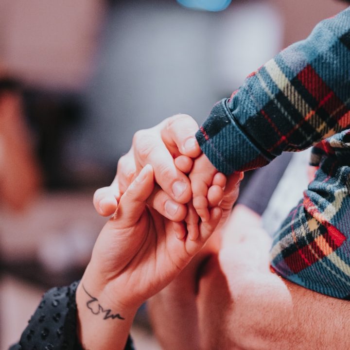 Famille en crise Deux mains se rejoignent, une adulte et une enfant, dans un moment tendre.